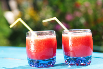 Watermelon lemonade in glass on blue wooden background, selective focus
