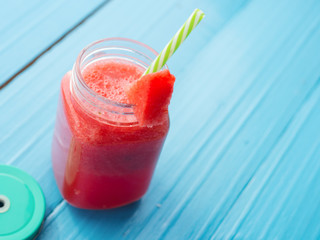 Lemonade in a glass jar with slices of lemon and mint on a wooden table