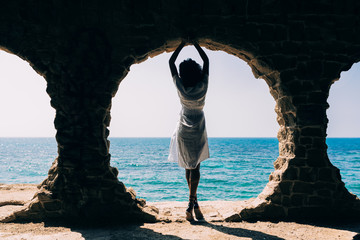 Rear view of young woman standing near sea