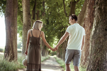 Junges Paar erträumt sich beim Spaziergang im Park eine gemeinsame Zukunft