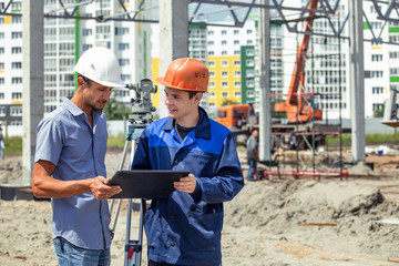 Engineer foreman gives orders to workers and builders who build a building on the construction site
