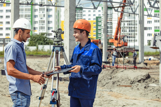 Engineer foreman gives orders to workers and builders who build a building on the construction site