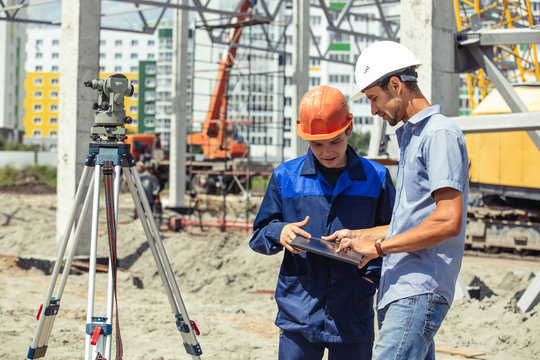 Engineer foreman gives orders to workers and builders who build a building on the construction site