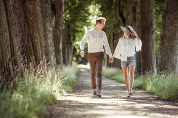 young man and woman walking closely in a park