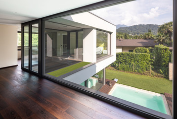 Large window in hallway of modern villa overlooking the private pool - obrazy, fototapety, plakaty