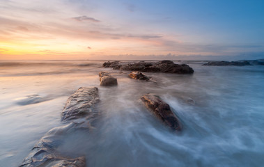 sunset seascape with waves trails. soft focus due to slow shutter and water movement.