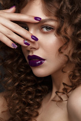 Beautiful girl with evening make-up, purple lips, curls and design manicure nails. beauty face. Photos shot in studio.