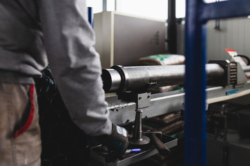 Metallurgy heavy industry. Factory for production of heavy pellet stoves and boilers. Worker hands close up. Extremely dark conditions and visible noise.
