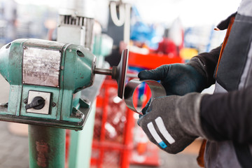 Metallurgy heavy industry. Factory for production of heavy pellet stoves and boilers. Worker hands close up. Extremely dark conditions and visible noise.