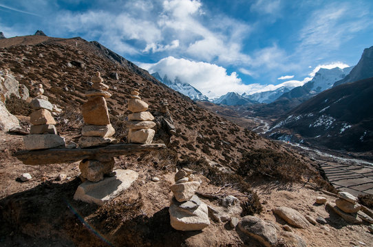 Stack of stones on mountain against cloudy sky