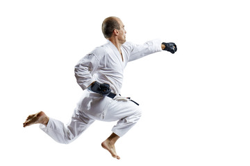 A man in black gloves trains a punch with his hand in a jump isolated