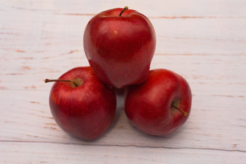 Red apples arranged on white wooden table