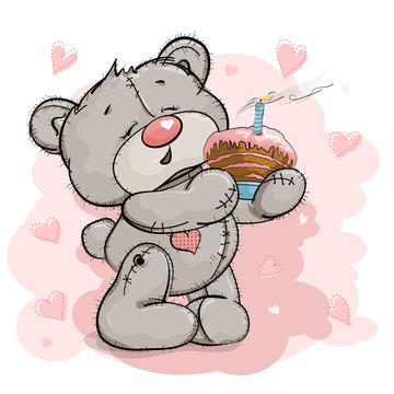A nice Teddy bear is holding a cake