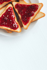 Toast with raspberry jam on a white background