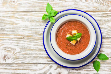 Healthy summer cold tomato soup, gazpacho with basil and garlic bread. Top view, space for text.