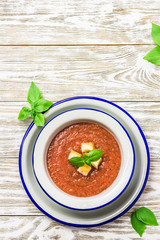 Healthy summer cold tomato soup, gazpacho with basil and garlic bread. Top view, space for text.