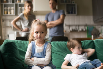 Frustrated kid girl feels upset, offended or bored ignoring avoiding worried parents and brother,...