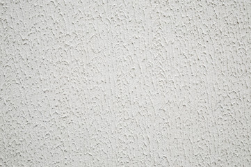 abstract background: Decorative plaster with a rough surface, painted with outdoor paint in white color