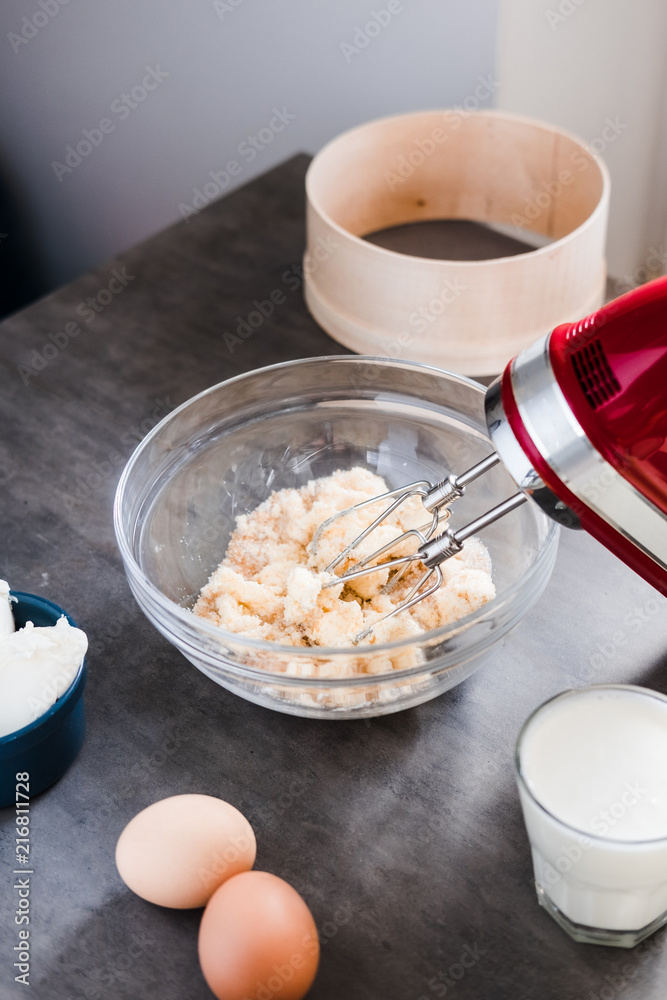 Wall mural MIxing baking ingredients in a bowl for cake or pancakes. Food photography styling concept