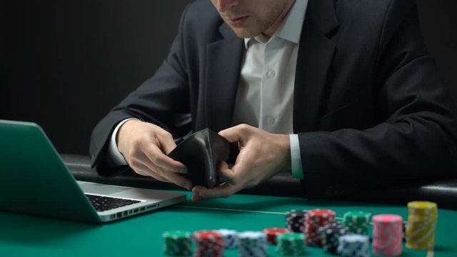 Nervous online gambler opening empty wallet, betting addiction, bankruptcy