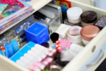 cosmetic stuffs in make-up drawer in blur