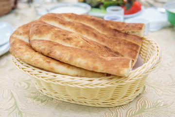 Fresh Homemade Bread in a white basket. Breakfast table.