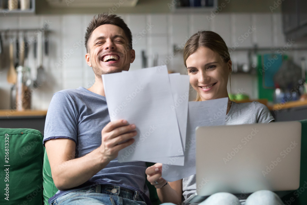 Sticker happy millennial couple laughing reading good positive funny information in paper bills or letters, 