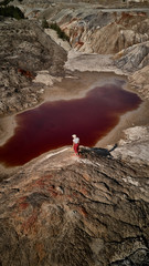 Woman with hat on background fantastic earth with red river at aerial view. Fantastic view. Martian landscape.