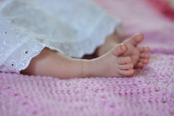 Obraz na płótnie Canvas newborn baby's feet on the pink blanket