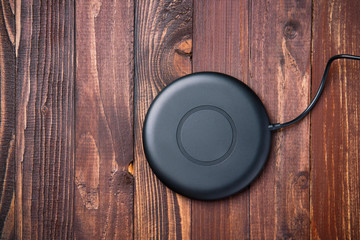 Wireless charger for mobile phone on a wooden background © jalisko