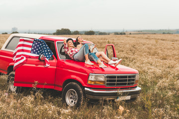 beautiful young girlfriends relaxing on car hood in field © LIGHTFIELD STUDIOS