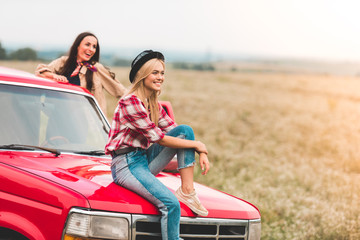 happy young girlfriends having car trip and looking at beautiful nature