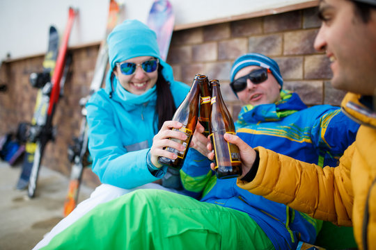 Photo of happy men and women in sunglasses with beer on winter day