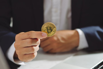 Golden Bitcoin in a Businessman hand, Digitall symbol of a new virtual currency