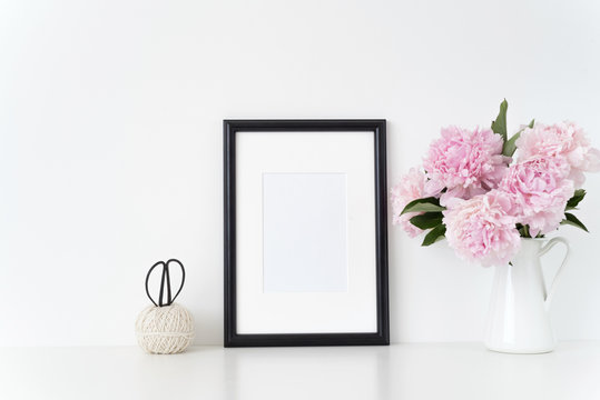 White portrait frame mock up with a pink peonies beside the frame, overlay your quote, promotion, headline, or design, great for small businesses, lifestyle bloggers and social media campaigns
