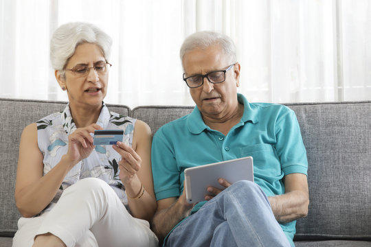 Senior couple shopping online using credit card on digital tablet