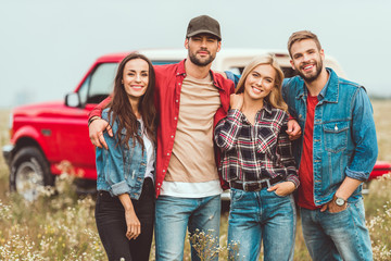 group of young people embracing and looking at camera in flower field