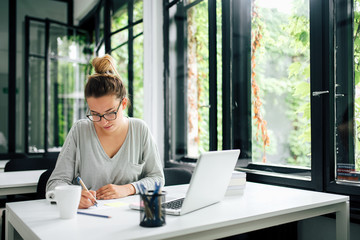 Young female student studying in library.