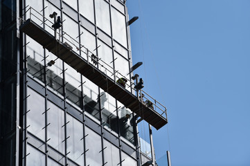 Construction workers on a suspended platform on a skyscraper