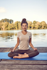 Fototapeta na wymiar Junge Frau macht eine Yoga Übung am See