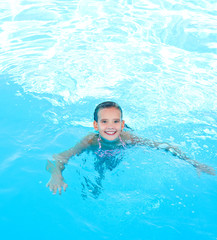 Fototapeta na wymiar Cute smiling happy little girl child in swimming pool