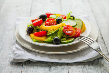 summer vegetable salad with olive oil on wooden backgroun