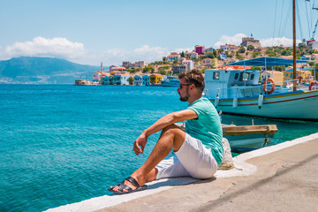 young man chilling at the harbor of Kastellorizo Meis islnd