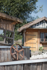 Fototapeta premium Focus on a steering wheel of a boat next to a house in Rustic village (Prokosovici, Bosnia)