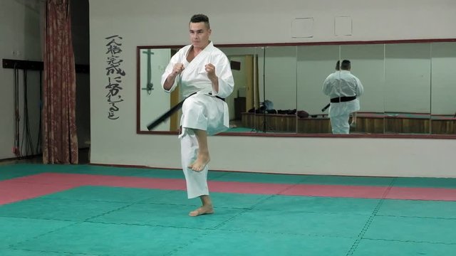 Young man with muscled body, training martial arts Goju-Ryu Karate-Do super slow motion