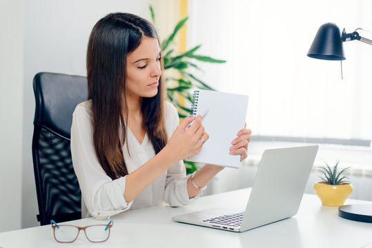 Tips list to do memory people person concept. Portrait of charming pretty smart confident clever young woman demonstrating empty blank space in notebook during sittin at the desk with laptop