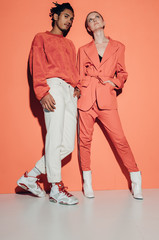 Casual couple in red leaning against a red wall
