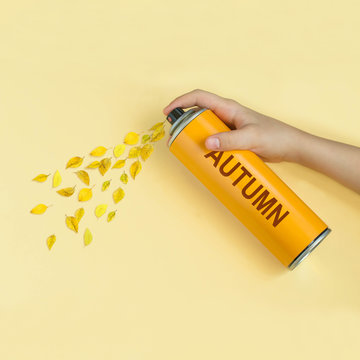 Yellow leaves fly from spray can with inscription: autumn