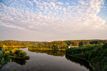Obraz premium Colourful sunset over a lake. Summer scene of wide river landscape with setting sun.
