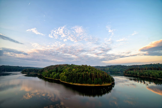 Colourful sunset over a lake. Summer scene of wide river landscape with setting sun.